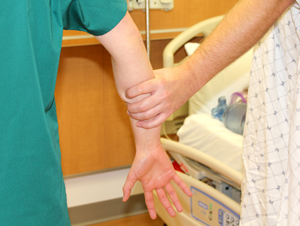 a healthcare worker's arm gripped tightly by a patient